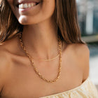 Woman wearing the gold PURELEI Fashion Show Necklace with fine hatching, perfect for stylish layering.
