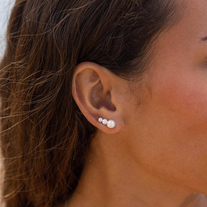 Woman wearing PURELEI Finesse Earrings in 18K Gold-Plated on her right ear, showcasing the elegant pearl ear cuff design.