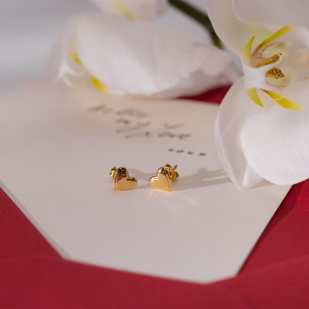 PURELEI Secret Love Earrings Gold, heart-shaped studs in 18K gold-plated stainless steel, displayed on a romantic love card.