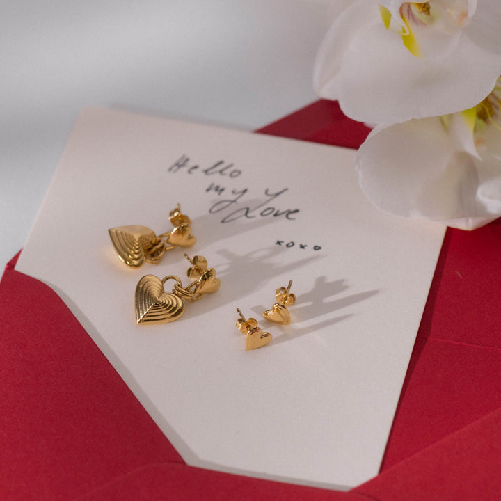 PURELEI Secret Love Earrings Gold paired with another set of earrings, elegantly placed on a romantic love card.