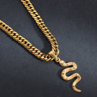 Goldene Panzerkette mit Schlangenanhänger auf dunklem Hintergrund, Herrenschmuck modern