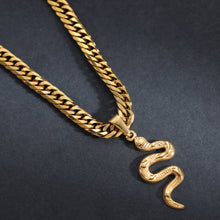 Goldene Panzerkette mit Schlangenanhänger auf dunklem Hintergrund, Herrenschmuck modern