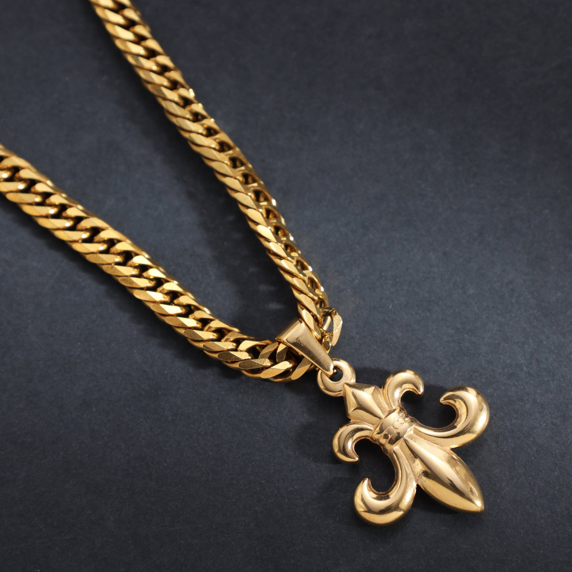 Goldene Panzerkette mit Lilienanhänger auf schwarzem Hintergrund, Herrenschmuck